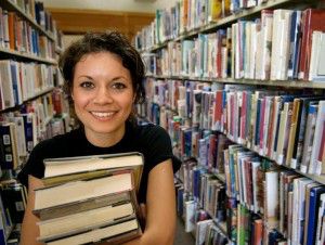 Lady looking excited carrying books out of a library